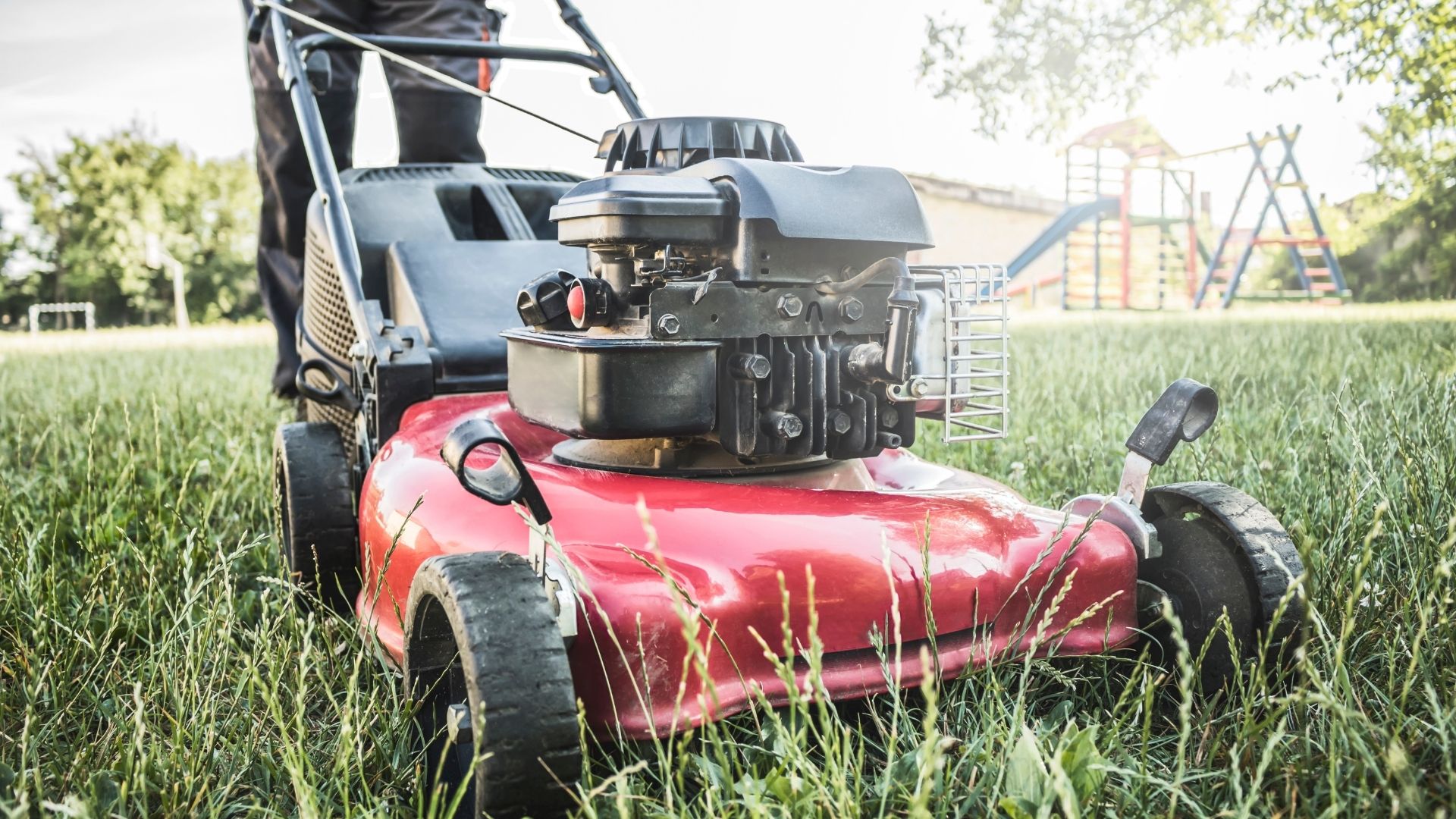 A man mowing the grass with a lawnmower